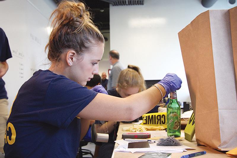 A Student examining mock crime scene evidence.